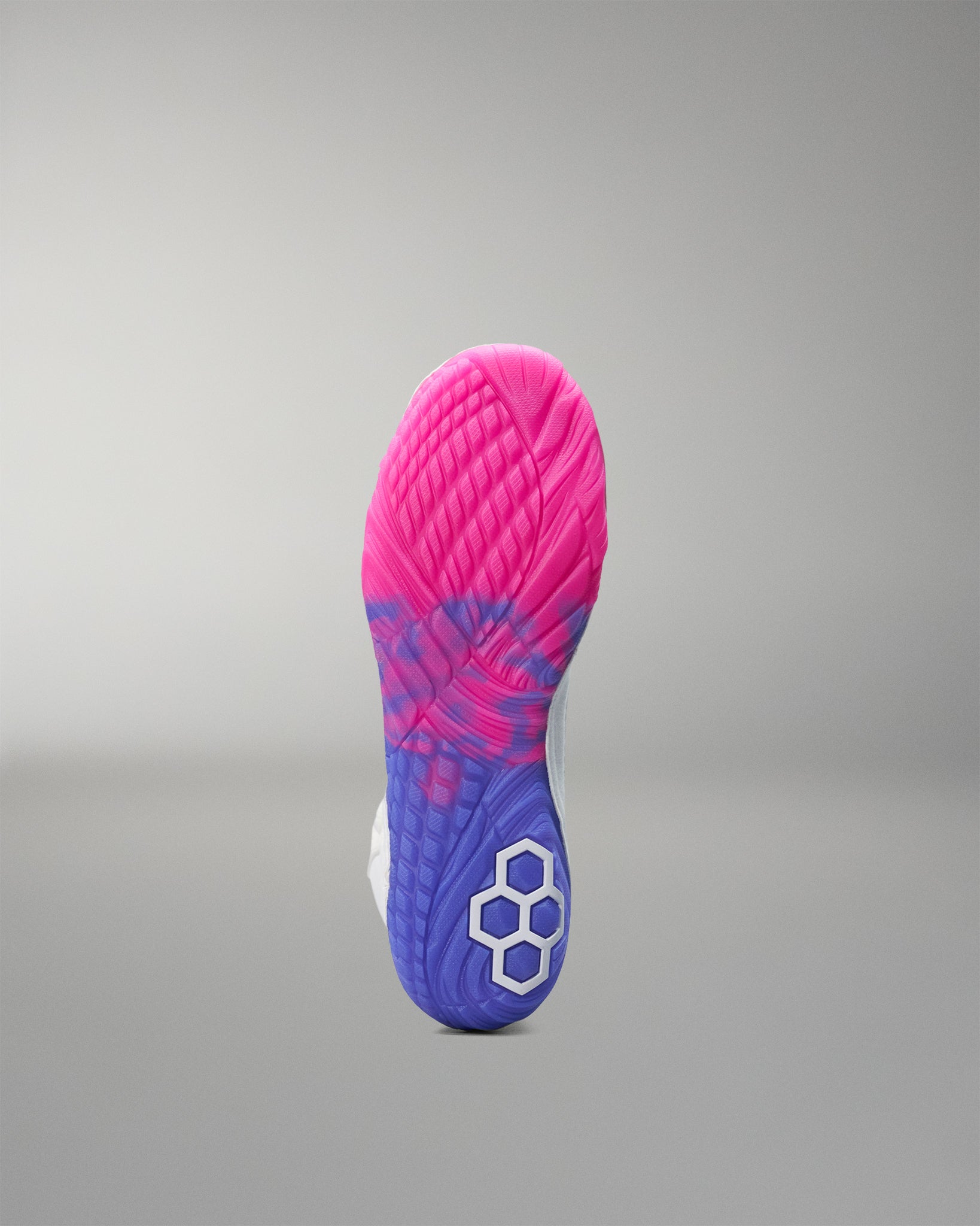 Close-up of a pink and blue wrestling shoe sole on a gray background