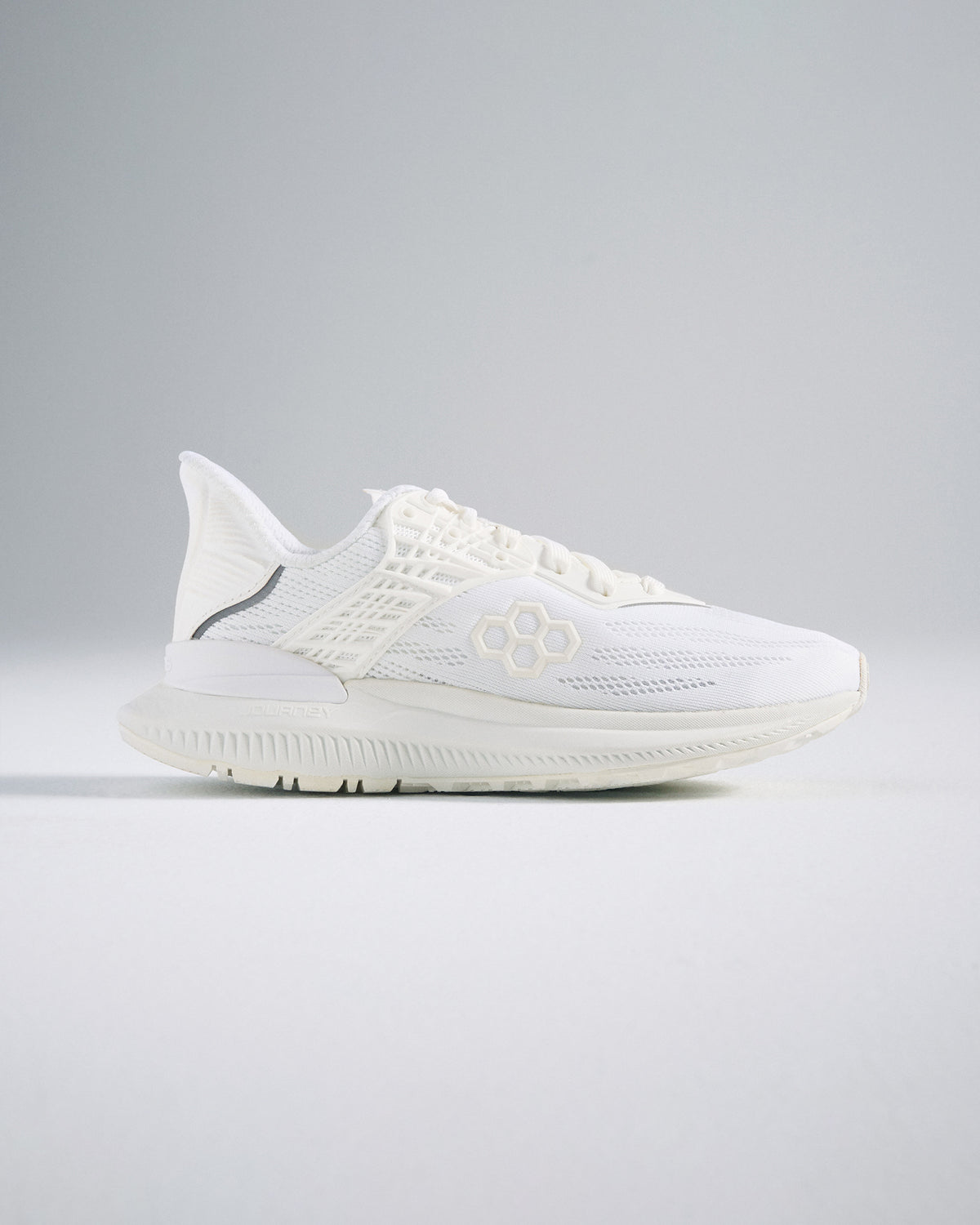 A sleek white athletic shoe featuring a breathable mesh upper textured sole and modern design elements for performance and style