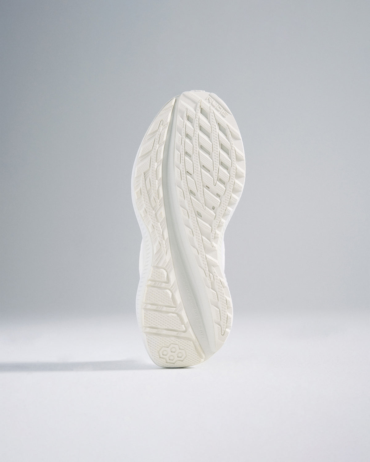 A close-up view of a sleek white athletic shoe sole featuring a detailed tread pattern for enhanced grip and performance