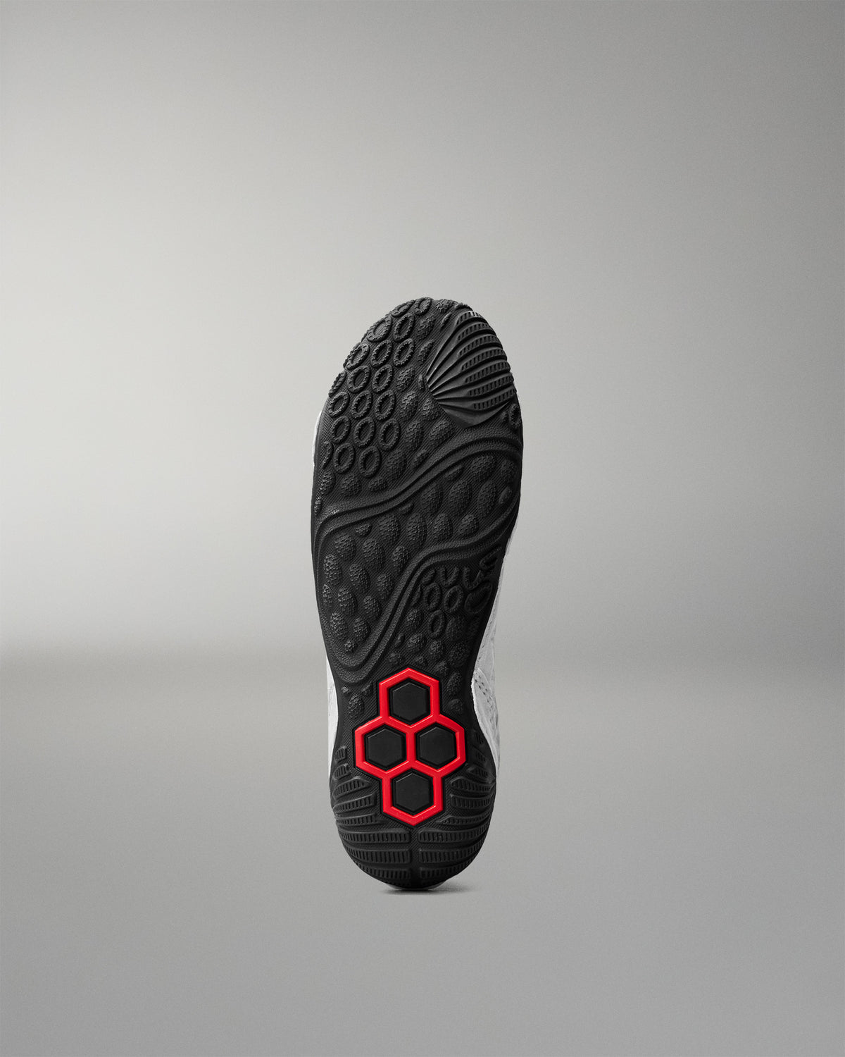 Bottom outsole view of RUDIS Infinity Edge wrestling shoe featuring aggressive traction pattern and red hex grip technology