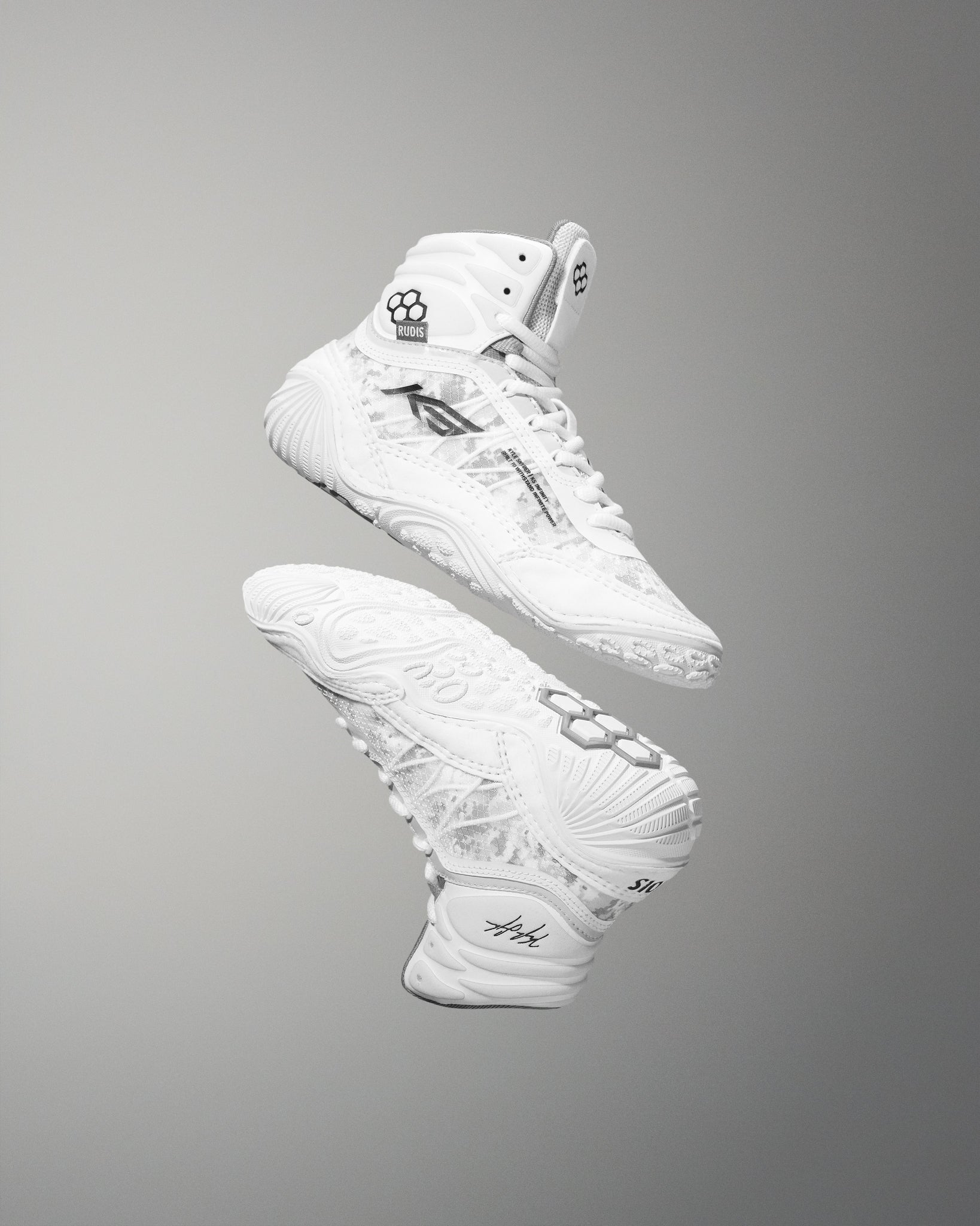 White high-top sneakers with RUDIS brand logo and Kyle Snyder KS logo on a gray background