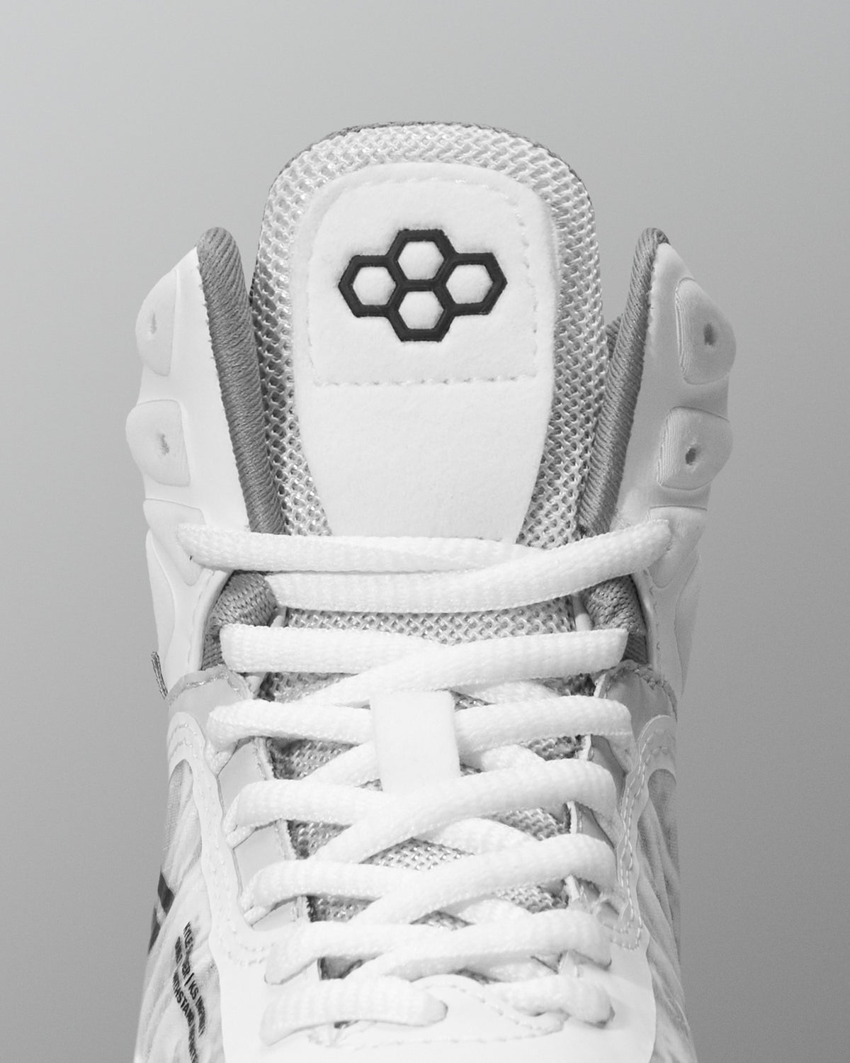 White wrestling shoe with a brand logo on a gray background