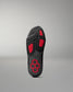 Black wrestling shoe sole with red accents on a gray background