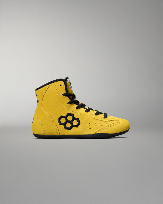 Yellow wrestling shoes with black RUDIS LOGO accents on a gray background