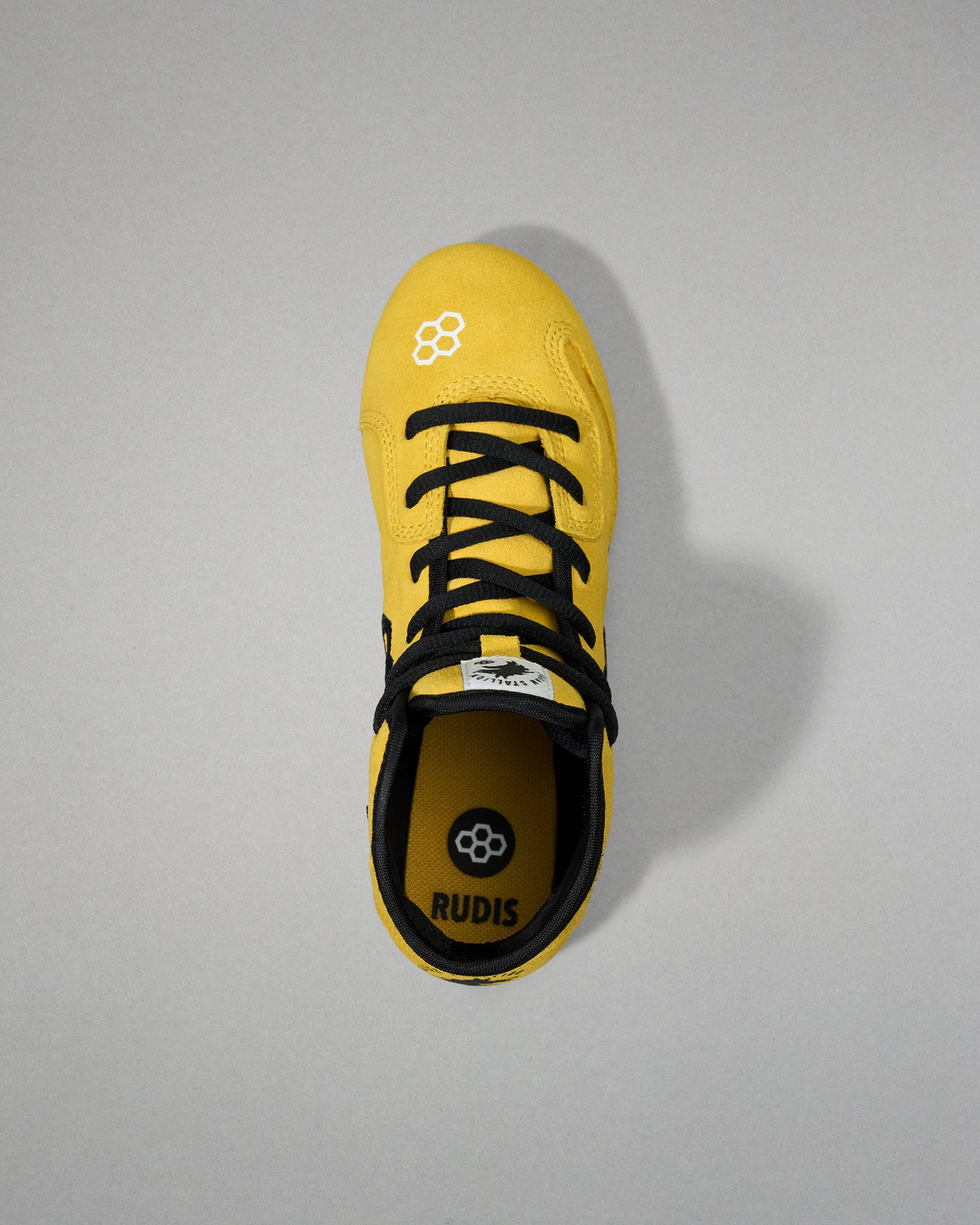 Top view - Yellow wrestling shoe with black laces on a gray background