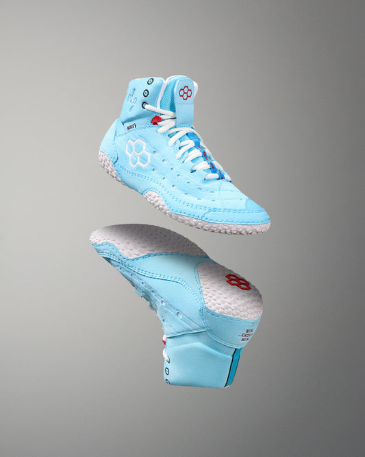 Light blue wrestling shoes with white laces on a gray background