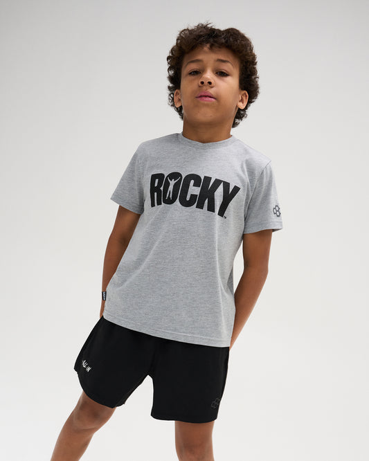 RUDIS Rocky Brand Youth T-Shirt in Gray, featuring bold black ROCKY lettering across the chest with a victory silhouette integrated into the graphic and RUDIS sleeve branding.