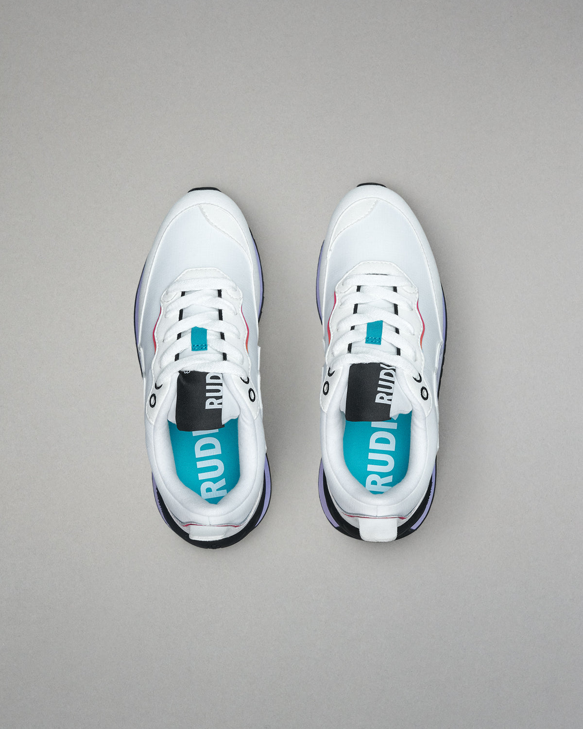 White sneakers with visible branding on a gray background