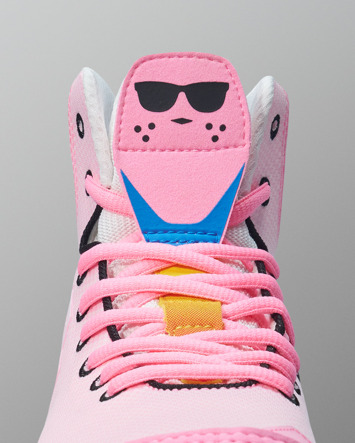 Pink wrestling shoe with sunglasses design on a gray background