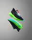 Black running shoes with green sole on a gray background