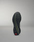 Black and green training shoe sole on a gray background