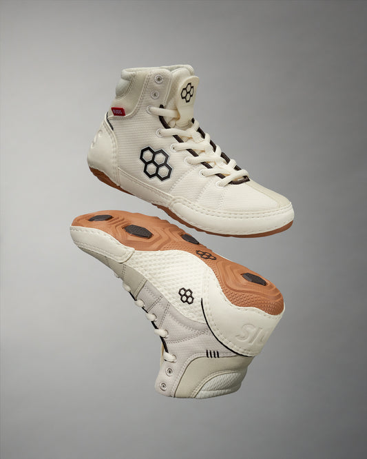 White wrestling shoes with brown soles on a gray background