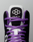 Close-up of a sneaker with purple laces and black and white accents on a gray background