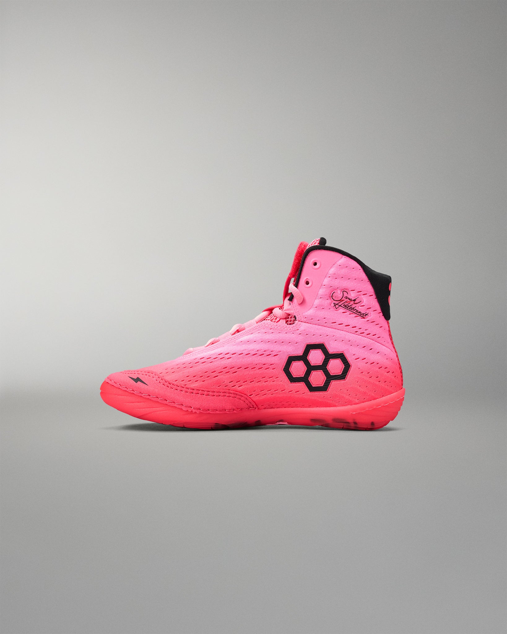 Pink wrestling shoe with a black logo on a gray background