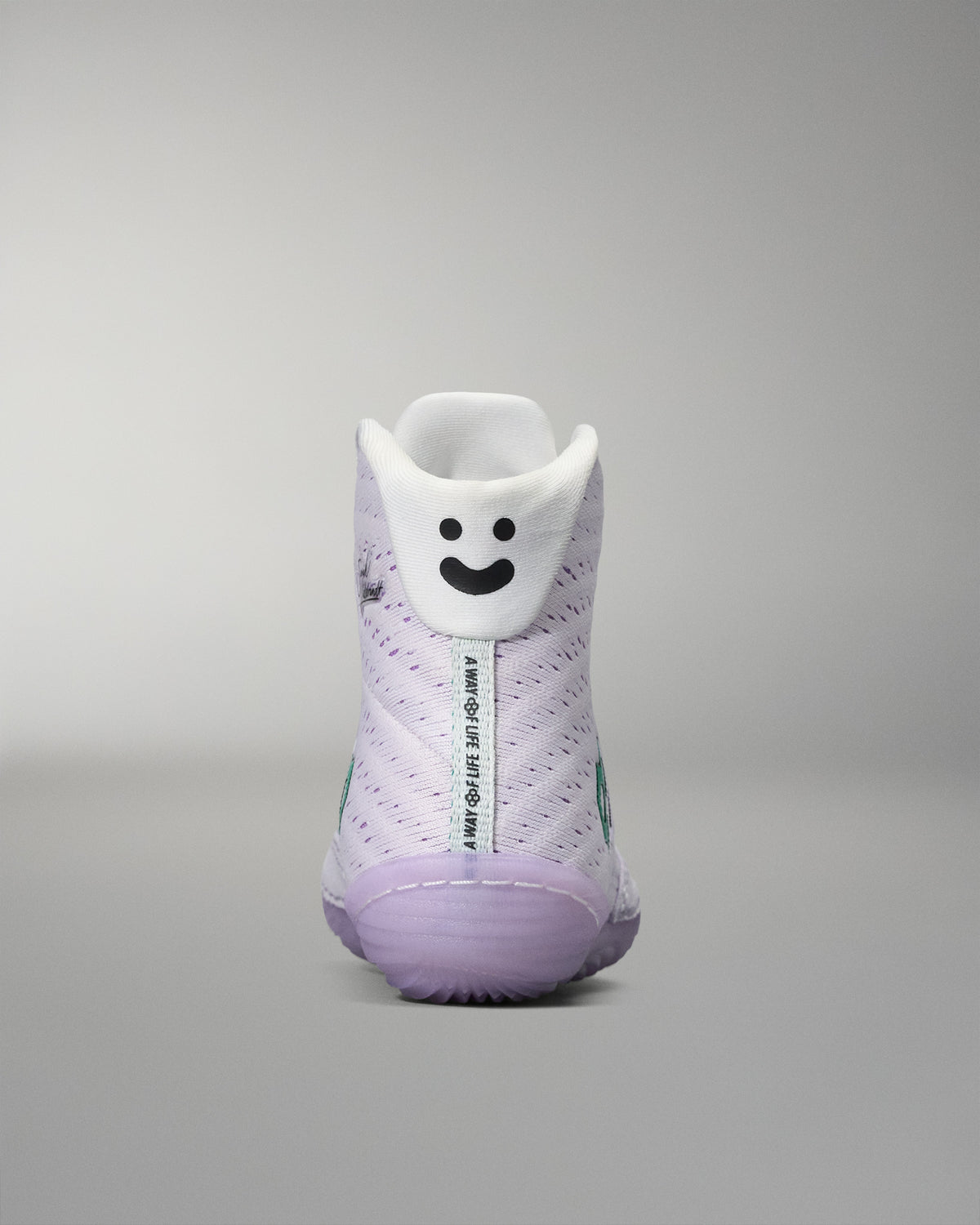 White sneaker with a smiley face design on a gray background