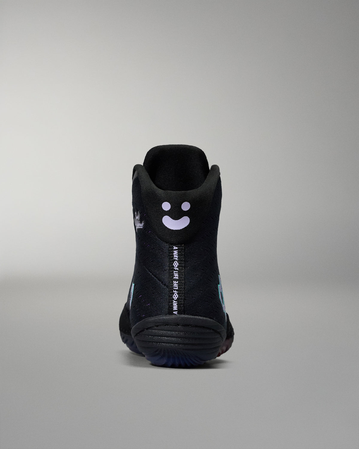 Black high-top sneaker with a smiley face design on a gray background