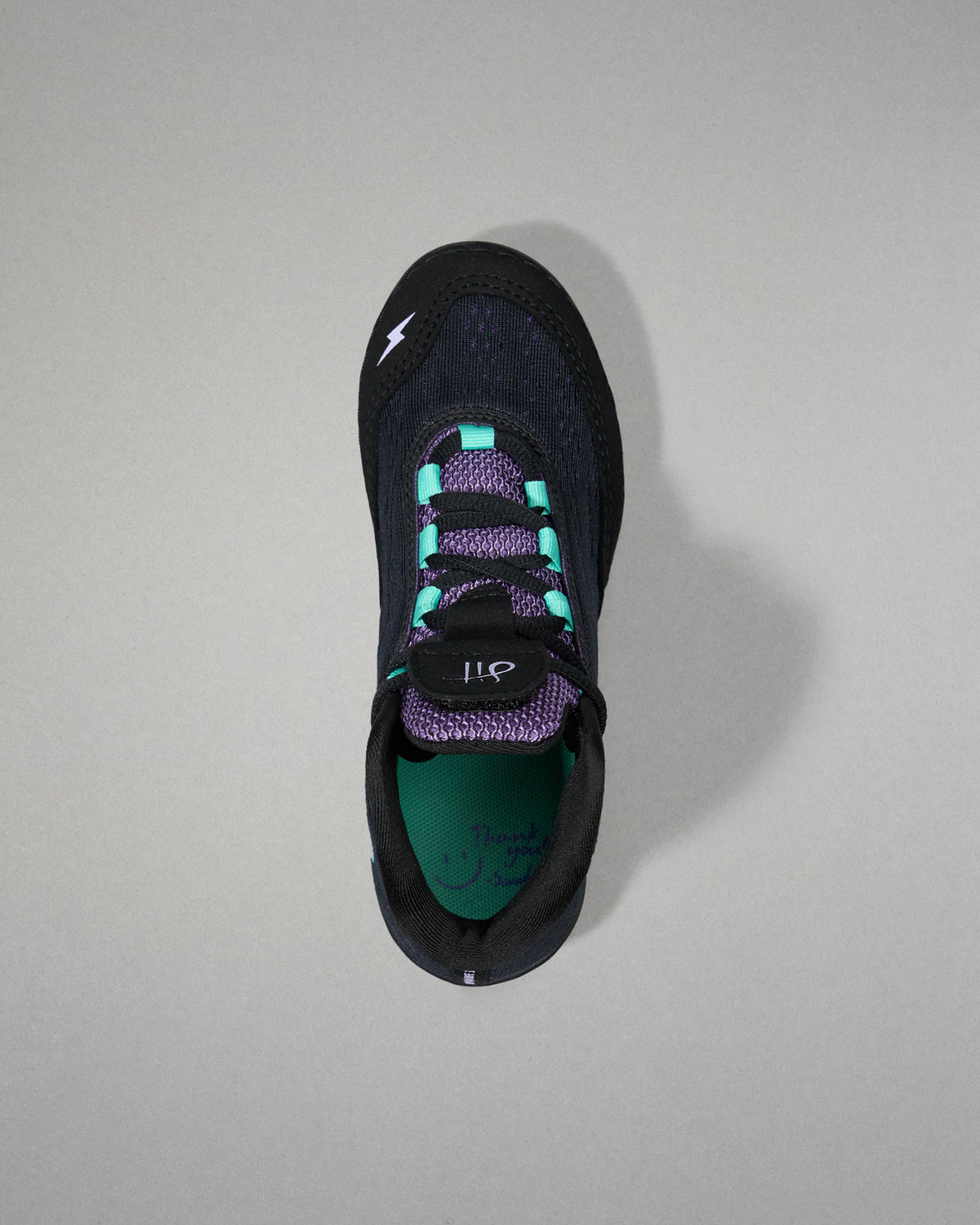 Black sneaker with purple accents on a gray background