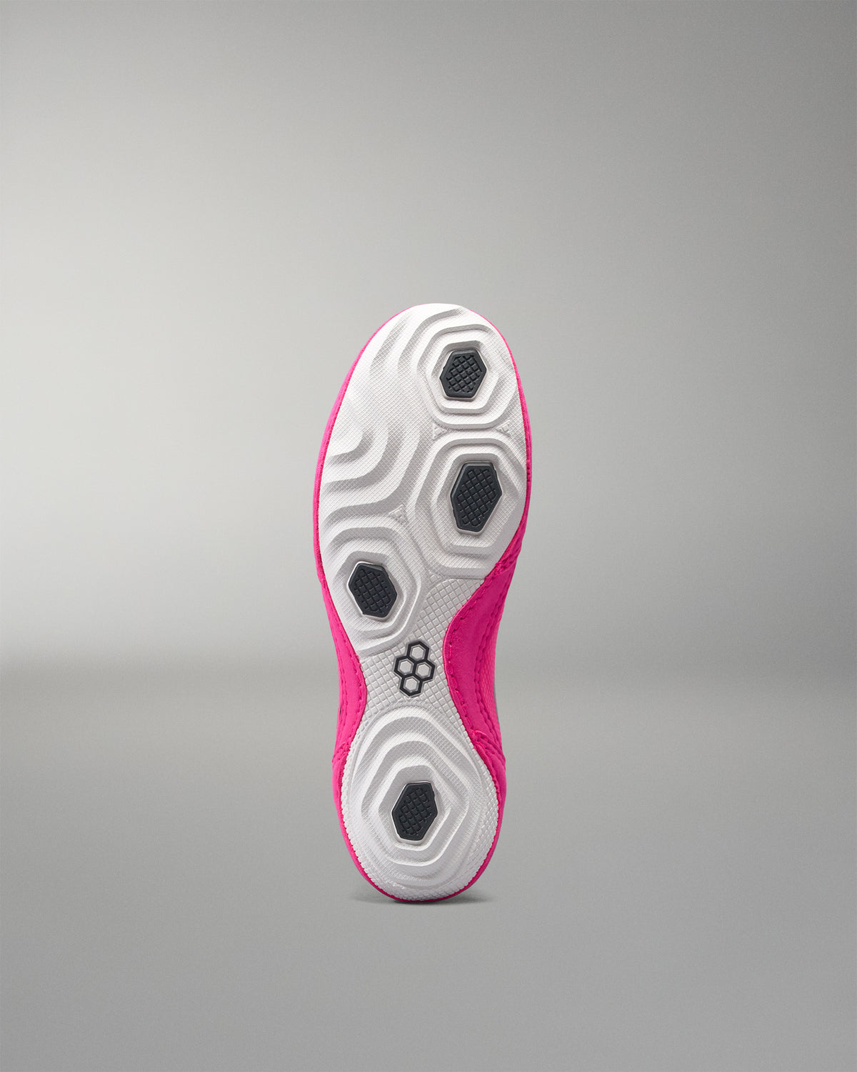 Sole of a pink and white athletic shoe on a gray background
