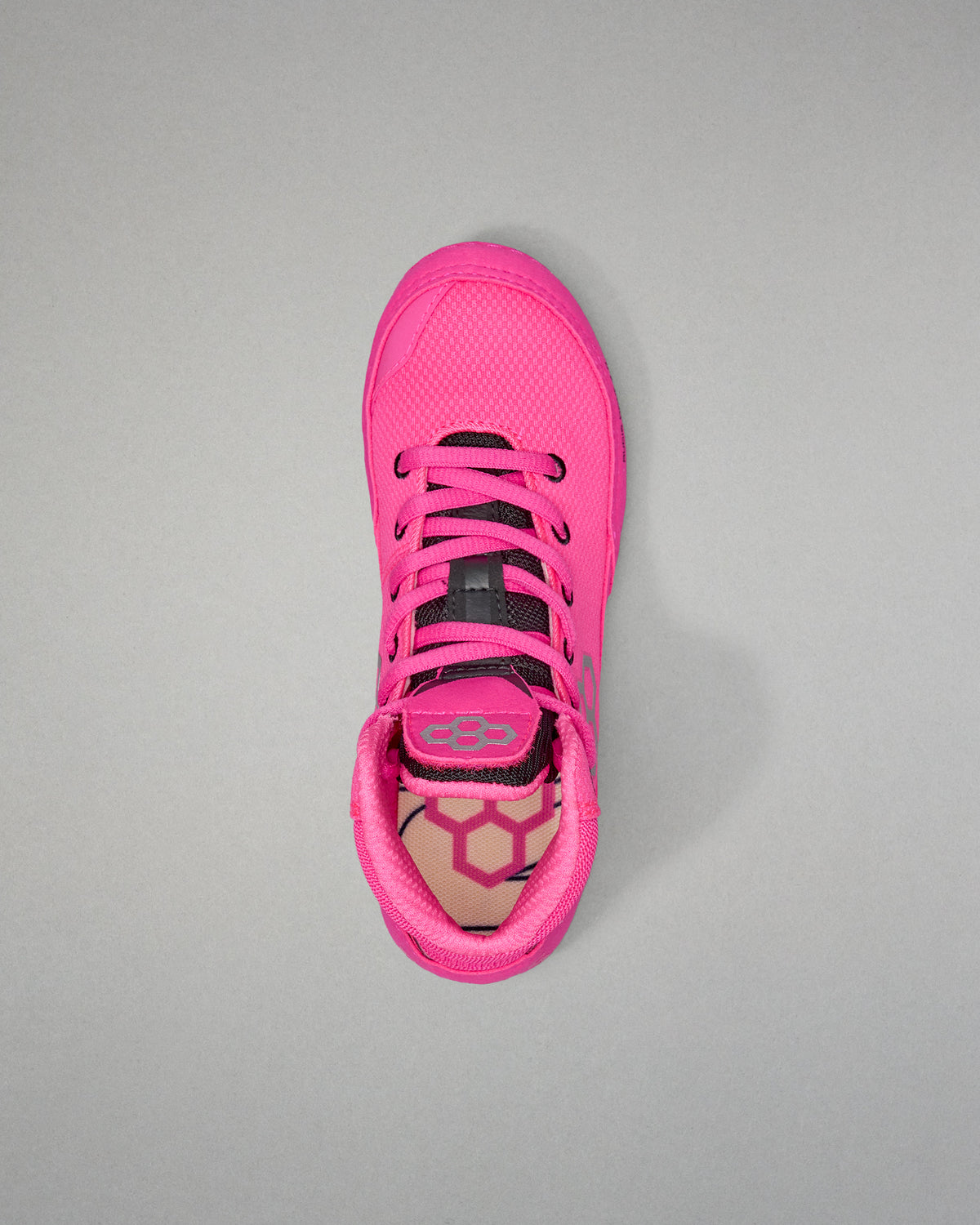 Pink athletic shoe with black laces on a gray background