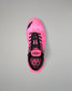 A single Wrestling shoe in vibrant pink with a geometric pattern, black laces, and black accents, photographed from a top-down perspective on a neutral gray background.