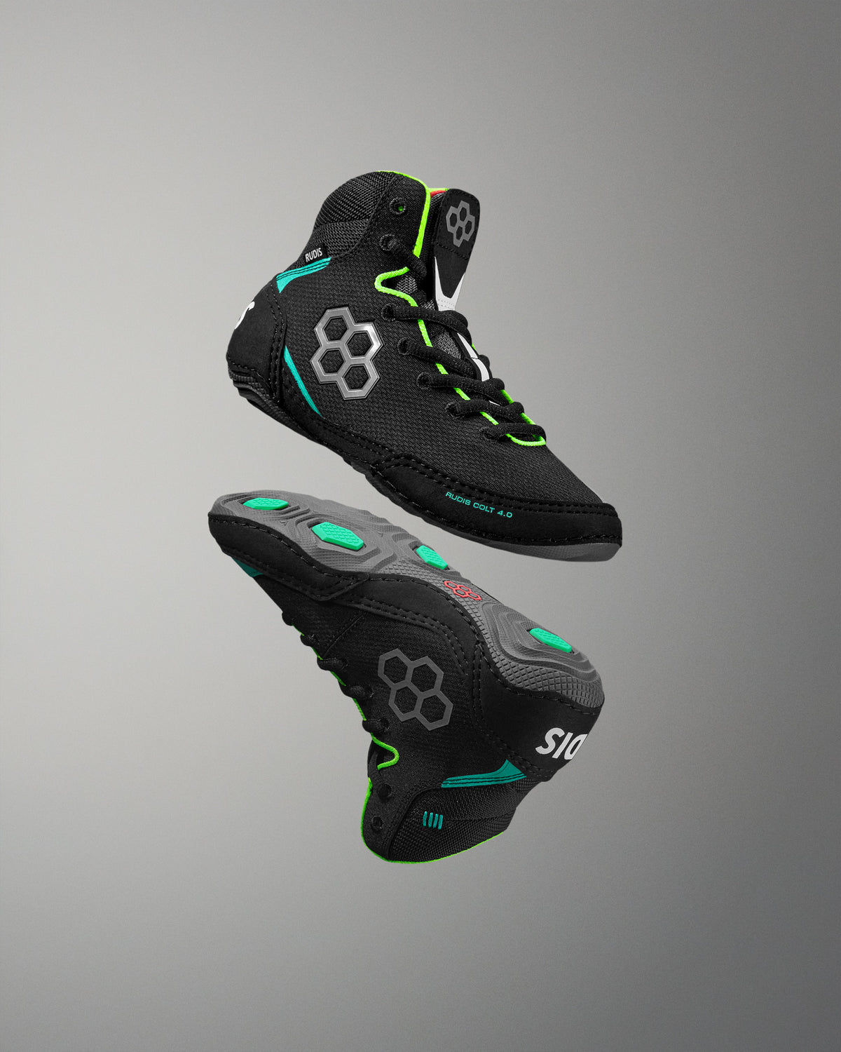 Black wrestling shoes with green accents on a gray background