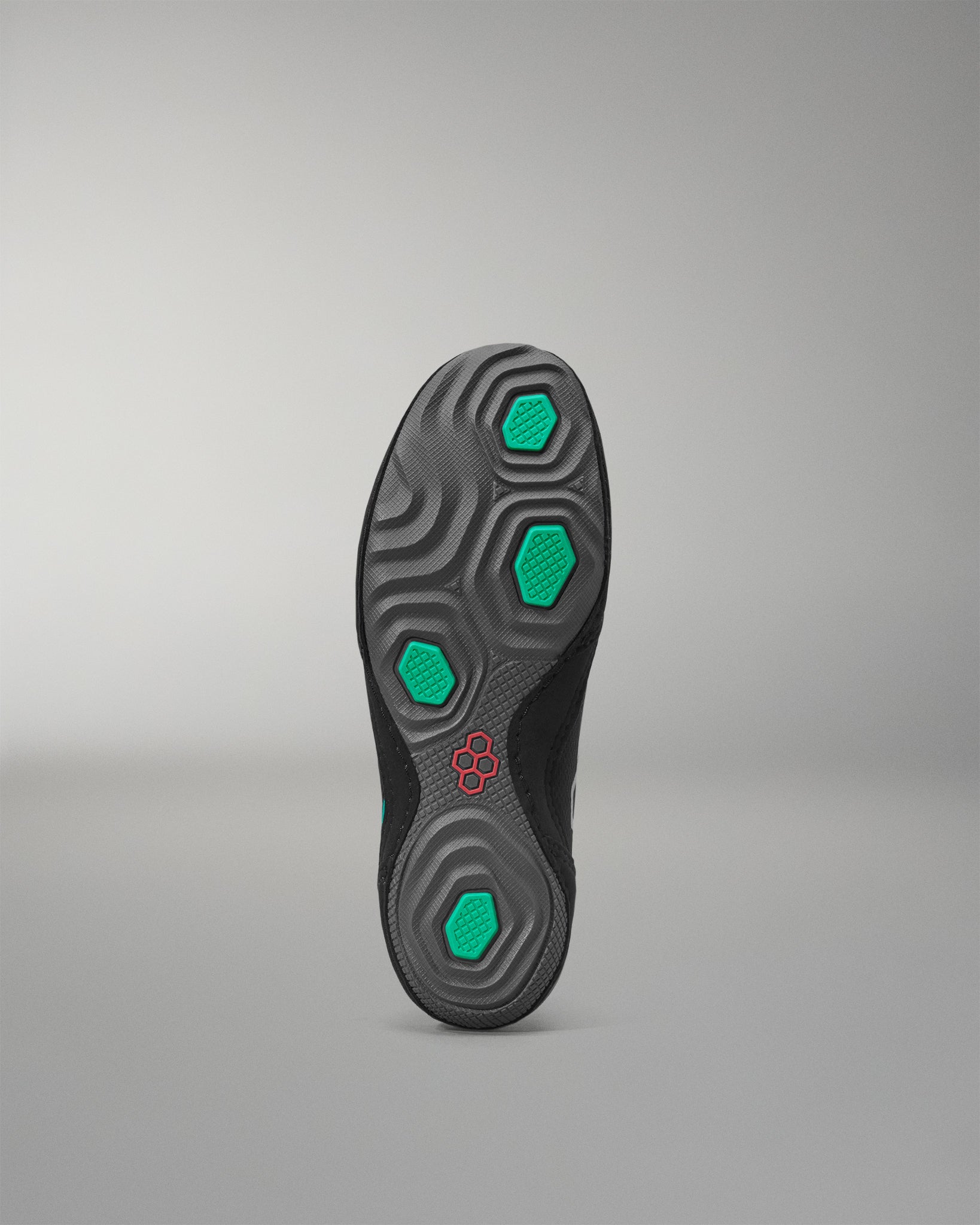 Sole of a wrestling shoe with green hexagonal patterns on a gray background