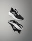 Black and white athletic shoe with brand logo on a gray background