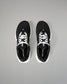 Black athletic shoes with white soles on a gray background