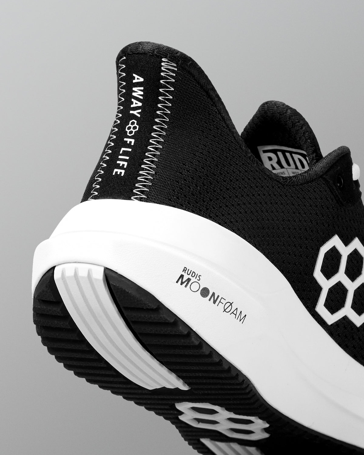 Black and white athletic shoe with branding on a gray background