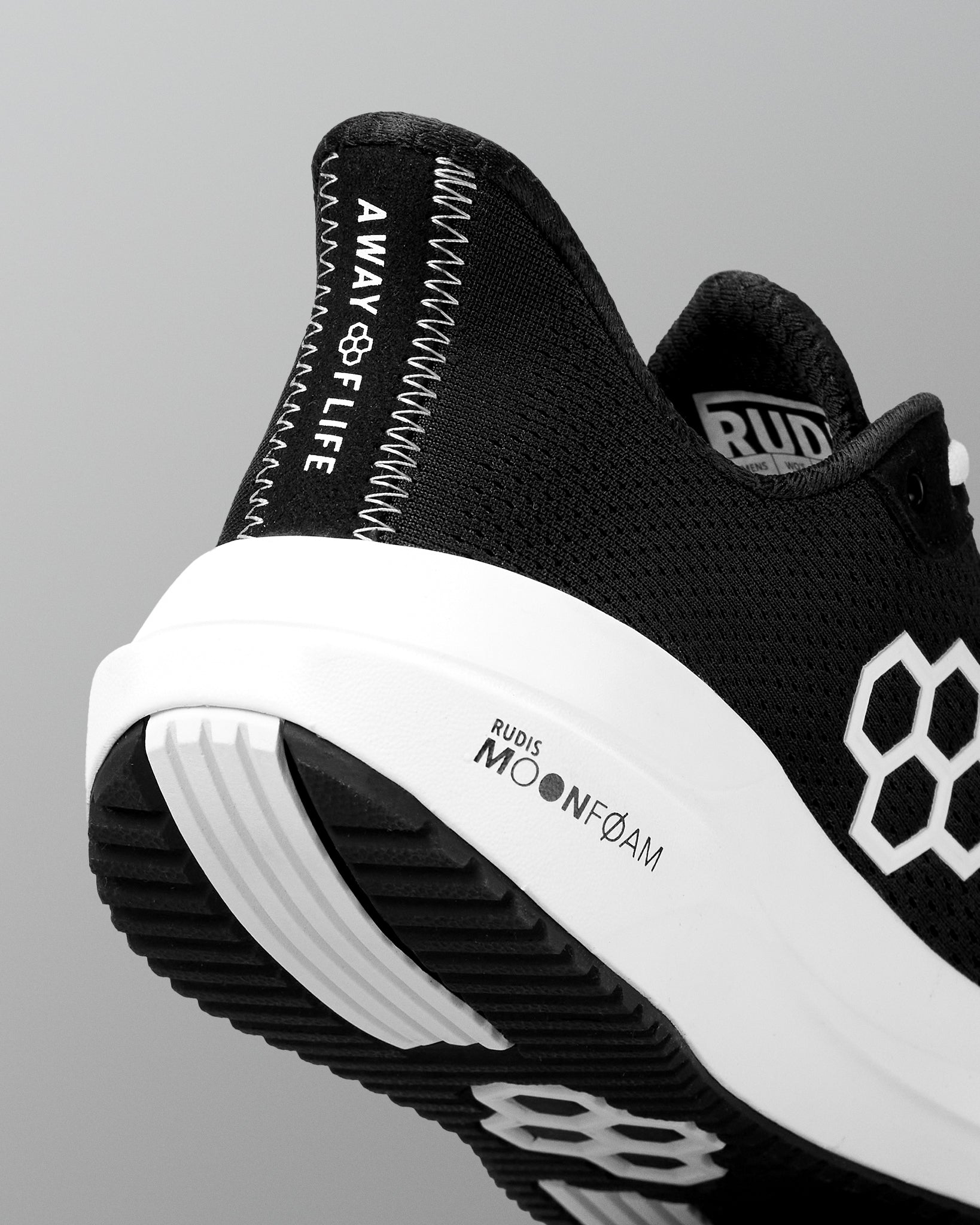 Black and white athletic shoe with branding on a gray background
