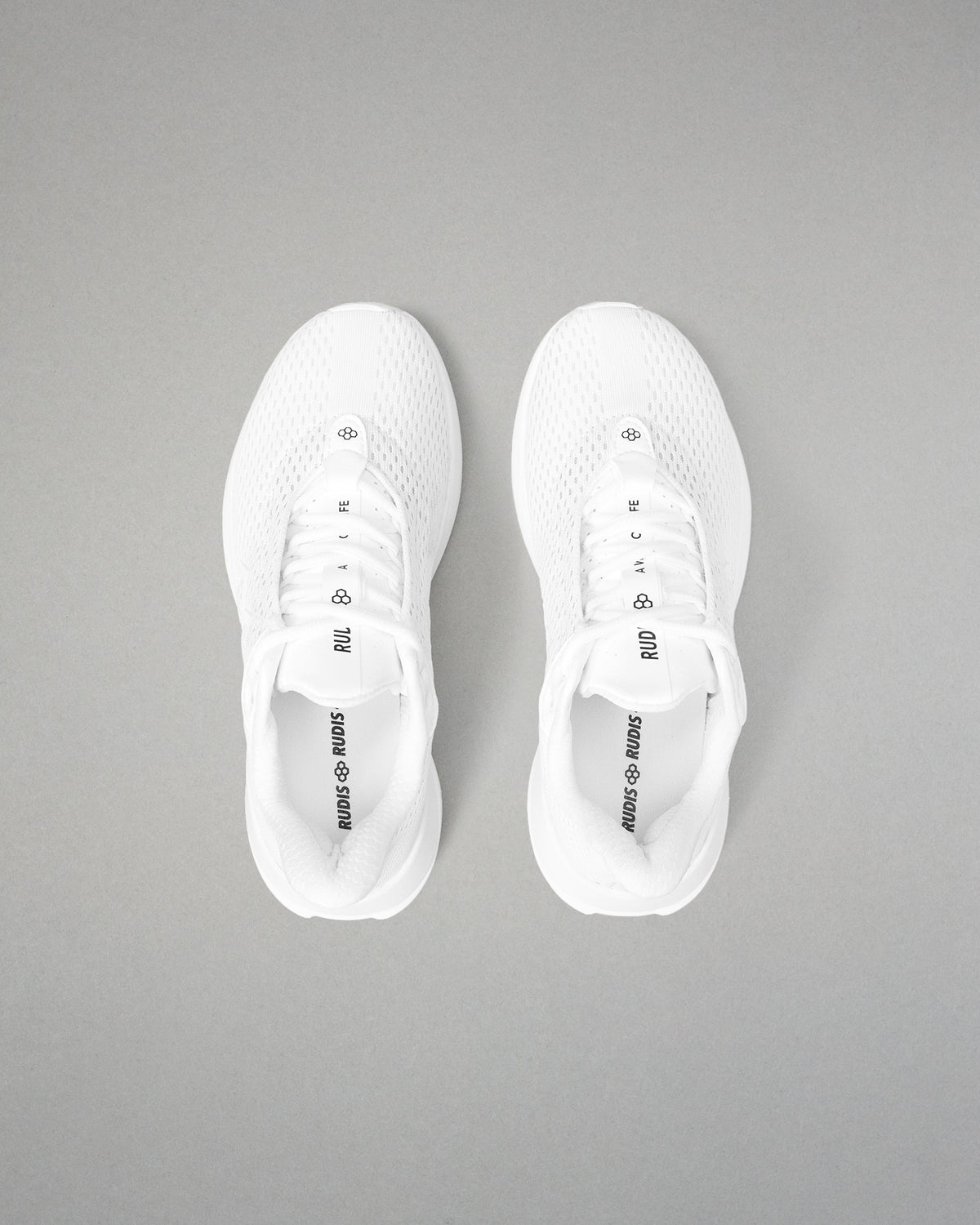 White sneakers with black text on a gray background