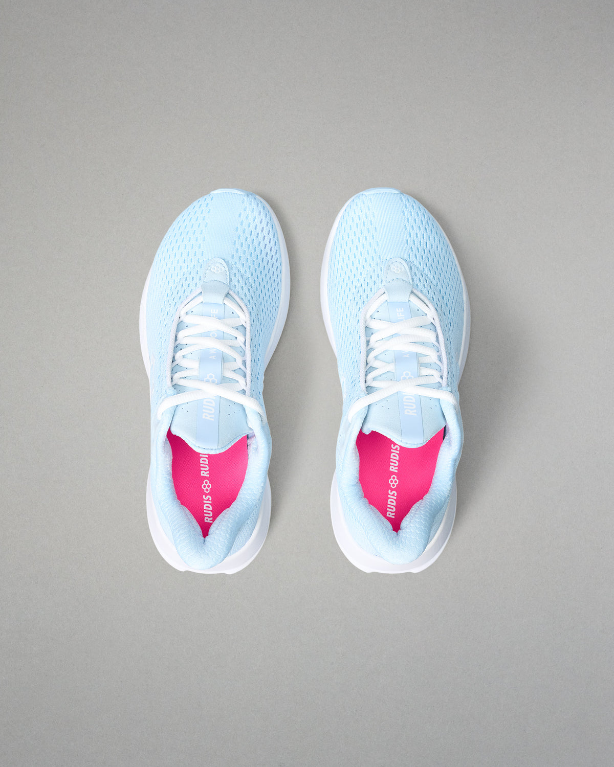 Light blue sneakers with white soles on a gray background