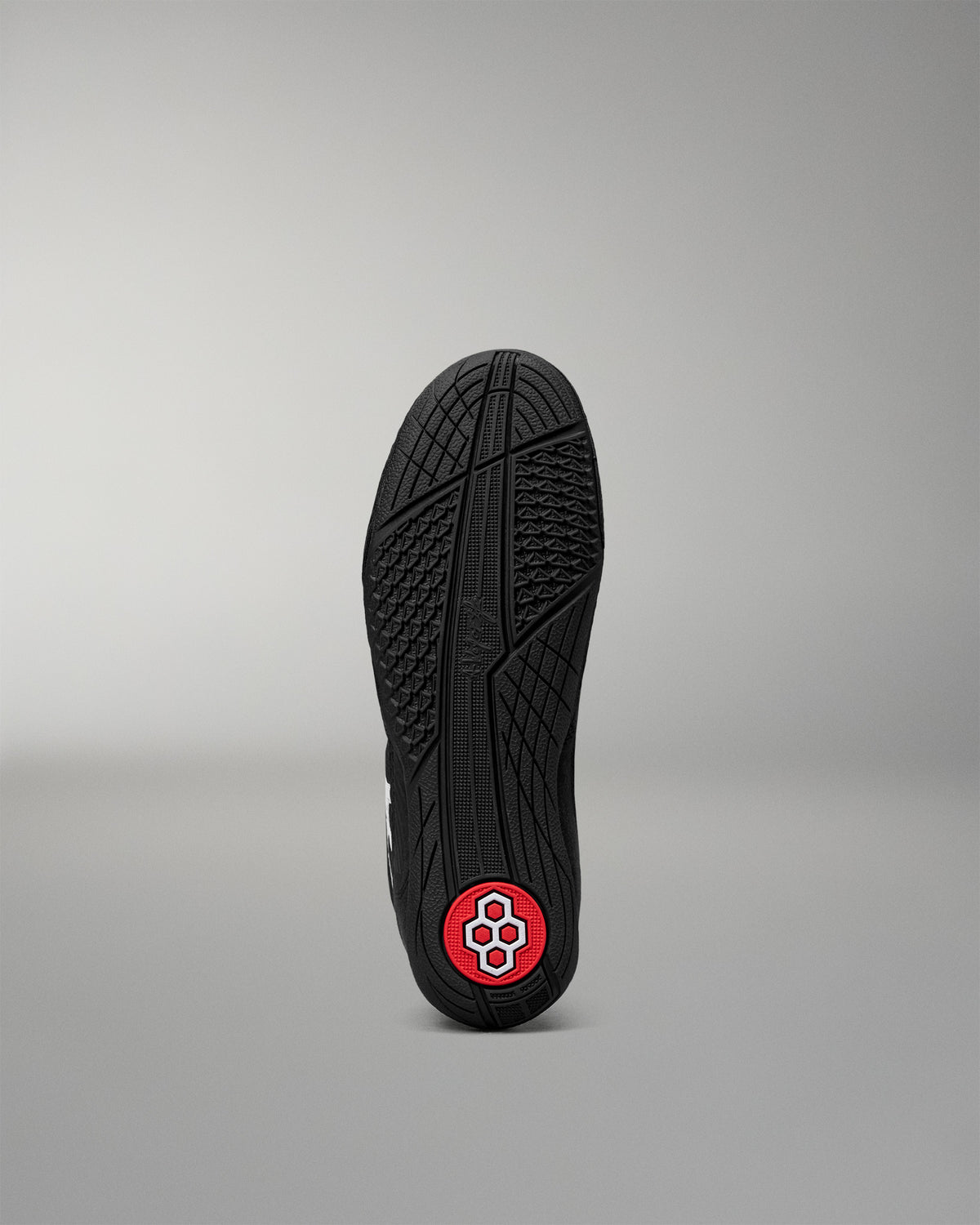 Bottom outsole of the RUDIS Courage 2.0 Youth Wrestling Shoe featuring a high-traction rubber tread with a red RUDIS logo pivot point.
