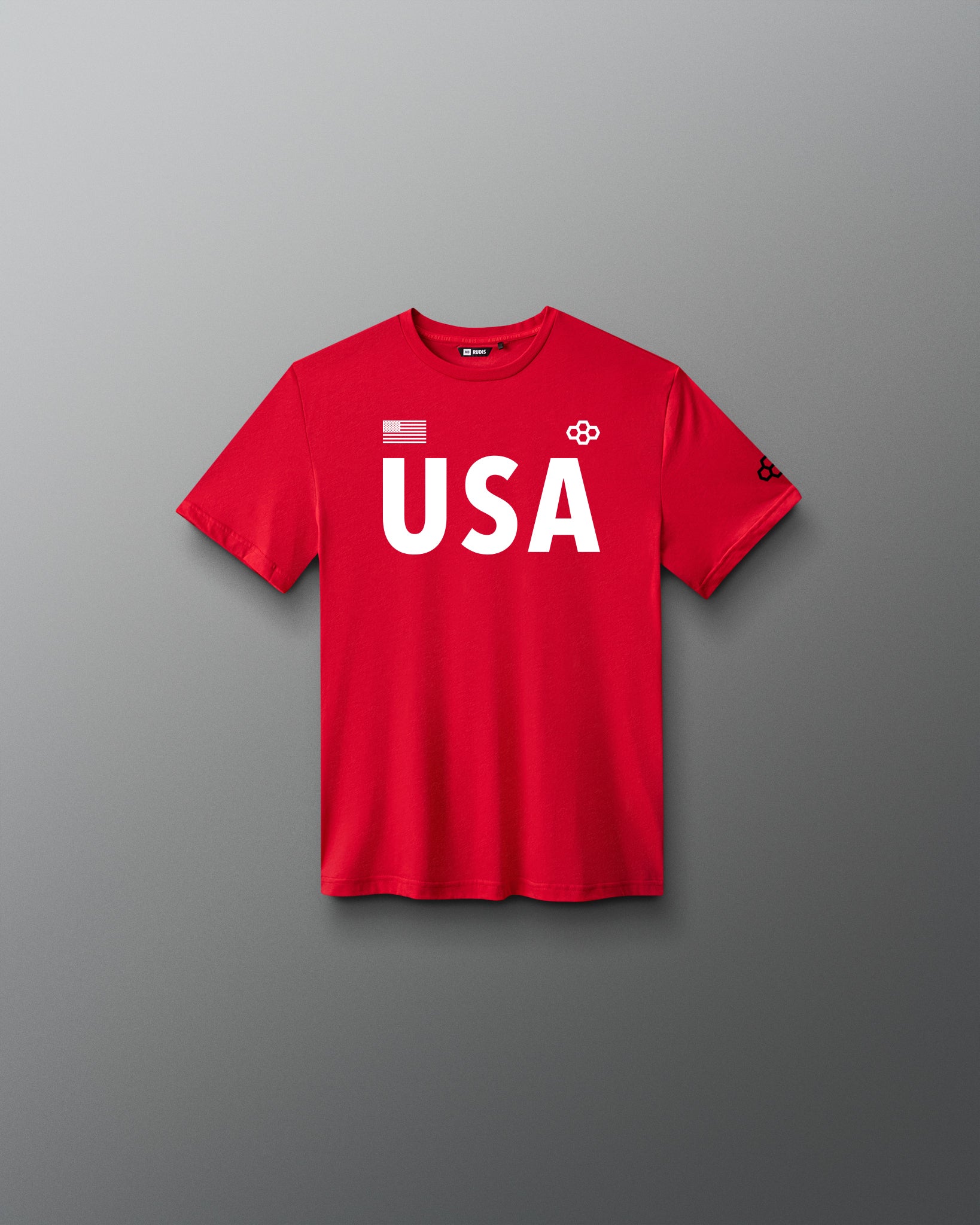 Front view of RUDIS USA Youth Elite Super Soft T-Shirt in red, featuring bold white USA lettering, an American flag graphic, RUDIS Hex logos, and a crewneck design.