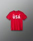 Front view of RUDIS USA Youth Elite Super Soft T-Shirt in red, featuring bold white USA lettering, an American flag graphic, RUDIS Hex logos, and a crewneck design.