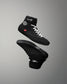 Black wrestling shoes with white laces on a gray background