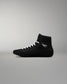 Black wrestling shoe with white laces on a gray background