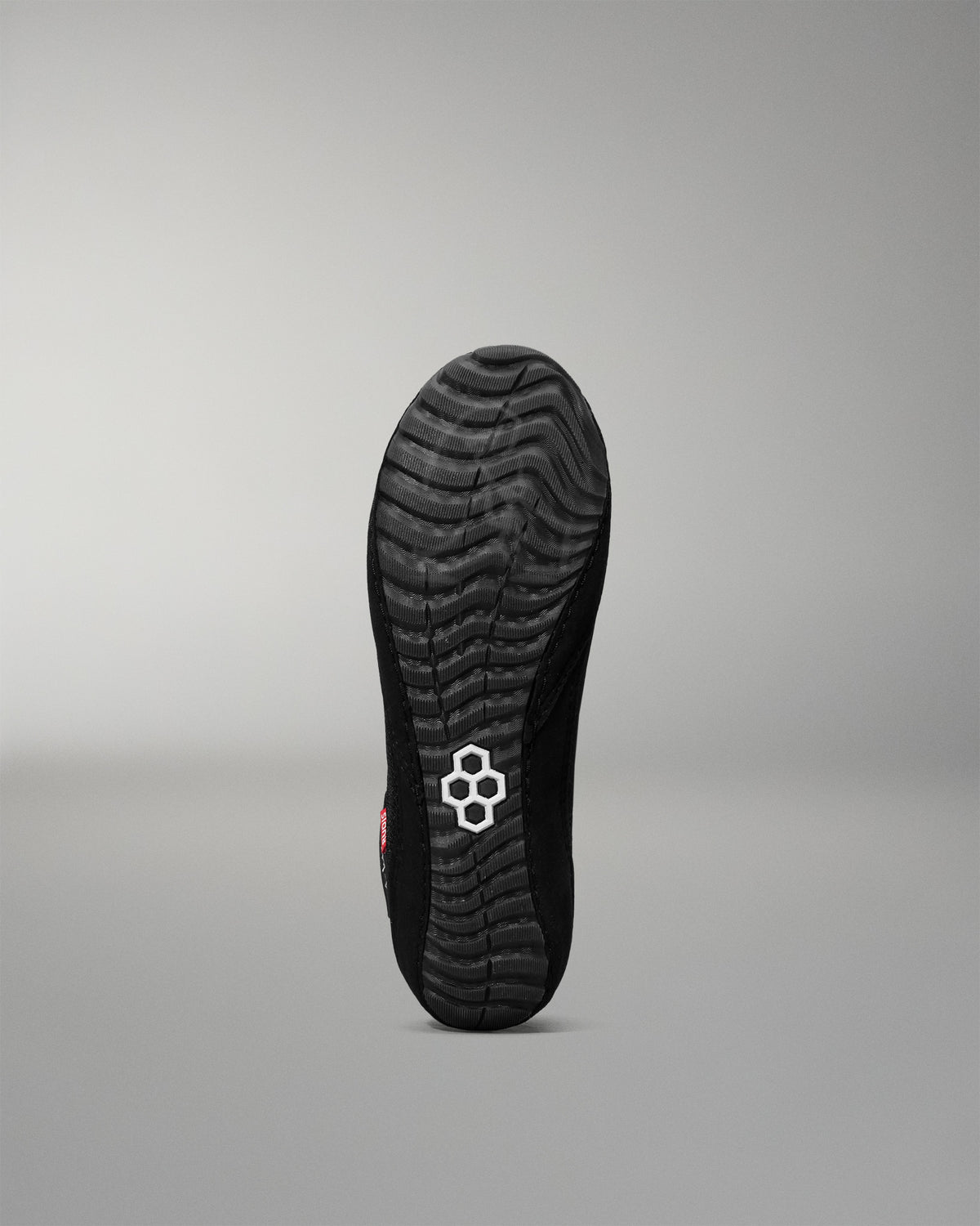 Black wrestling shoe sole with a brand logo on a gray background