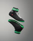 Black and green wrestling shoes with white laces on a gray background