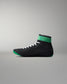 Black wrestling shoe with green accents on a gray background