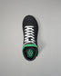 Black wrestling shoe with white laces and green sole on a gray background