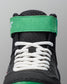 Close-up of a black wrestling shoe with white laces and green accents on a gray background