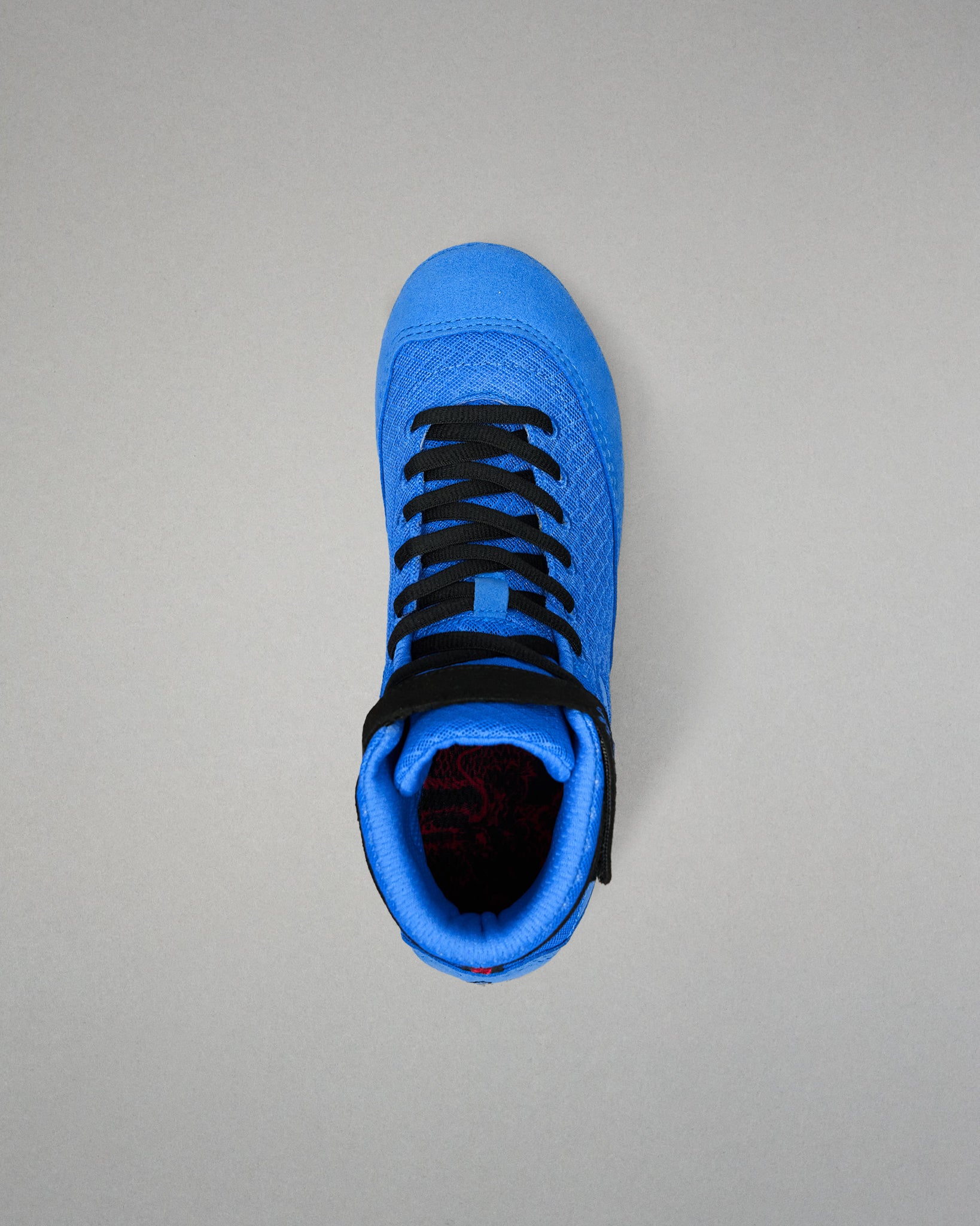 Top view of RUDIS Samurai Speed Ikigai youth wrestling shoe highlighting black laces, textured blue mesh tongue, padded collar, and ankle strap.