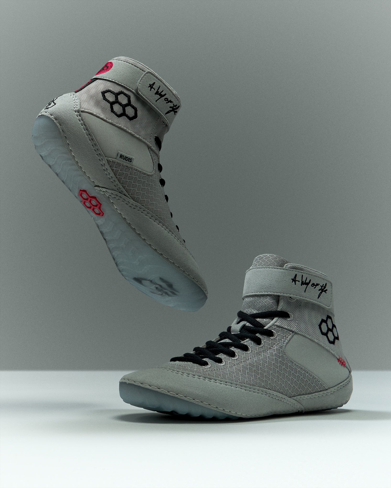 RUDIS Samurai Speed Youth Wrestling Shoes in Kokoro, featuring light gray mesh uppers, black laces, ankle straps, translucent blue outsoles, and red RUDIS accents.