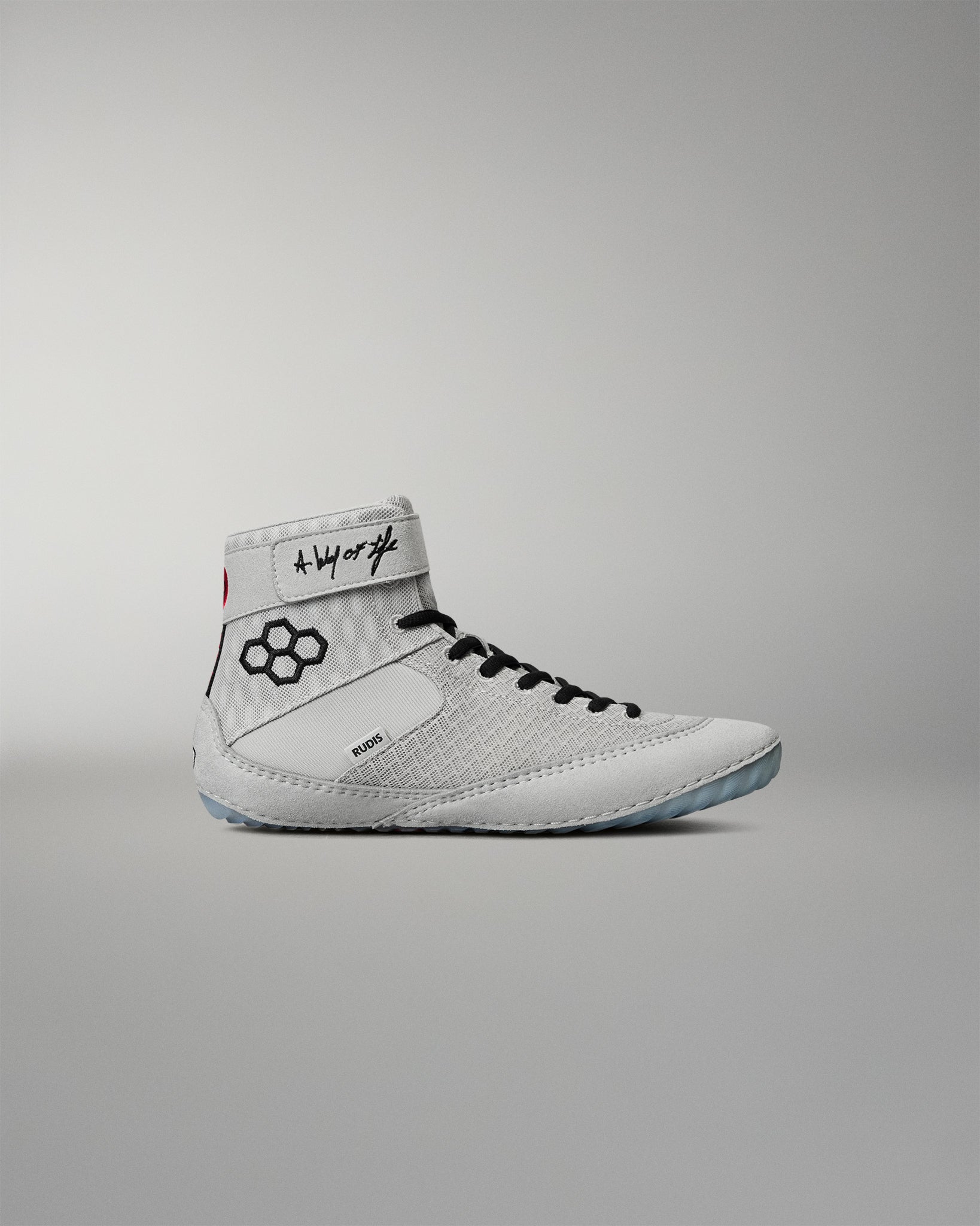 Lateral side view of the RUDIS Samurai Speed Youth Kokoro wrestling shoe, featuring a light gray mesh upper, black RUDIS emblem, ankle strap, and black laces.