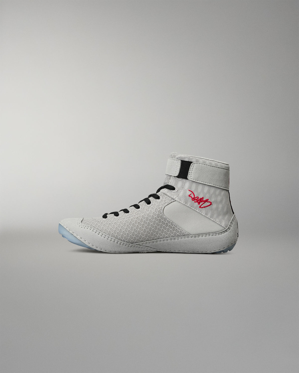 Medial side view of the RUDIS Samurai Speed Youth Kokoro wrestling shoe, showcasing textured gray mesh, black laces, red embroidered signature, and high-top ankle strap.