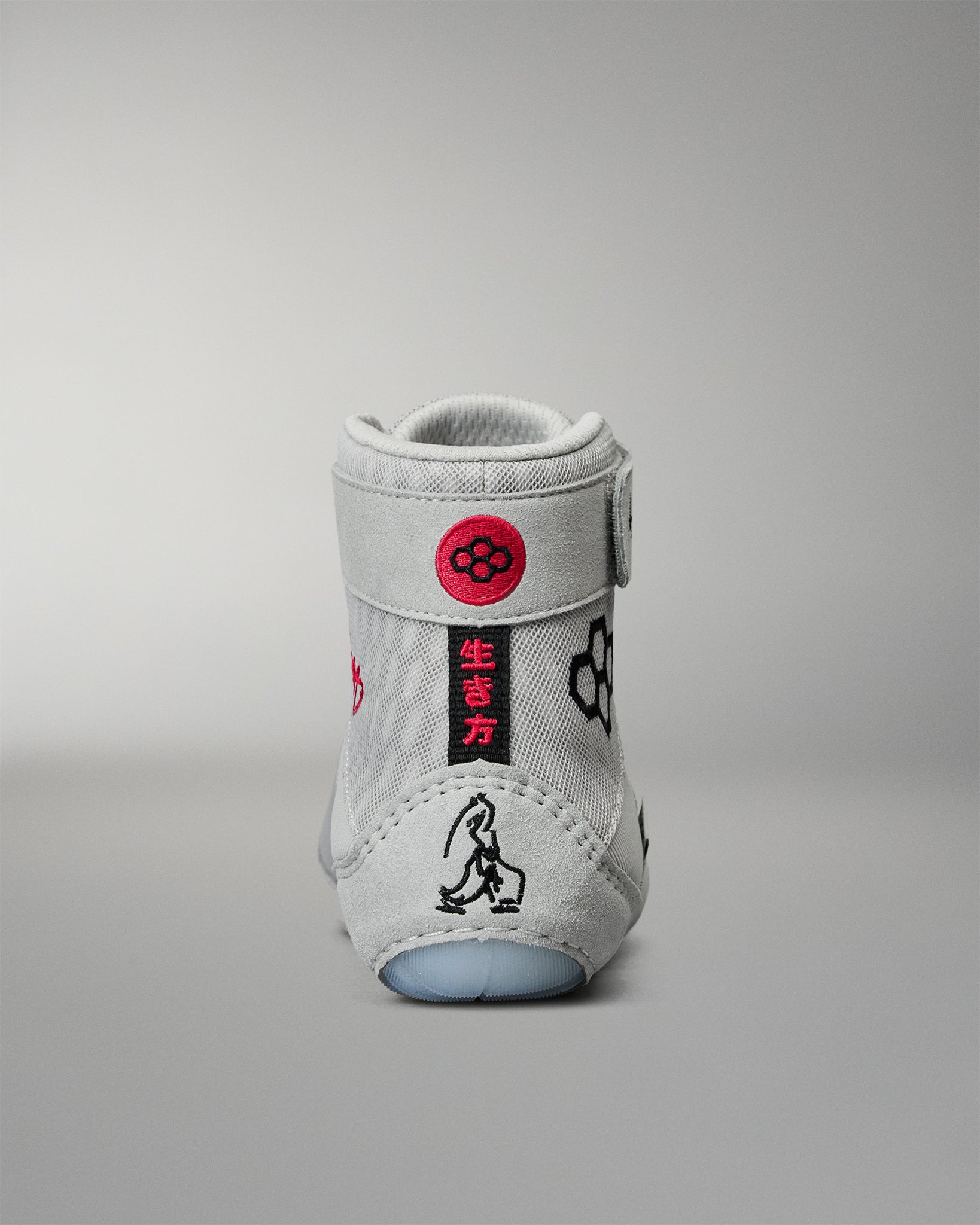 Rear view of the RUDIS Samurai Speed Youth Kokoro wrestling shoe, highlighting red Japanese lettering, embroidered RUDIS insignia, and black samurai-inspired heel artwork.