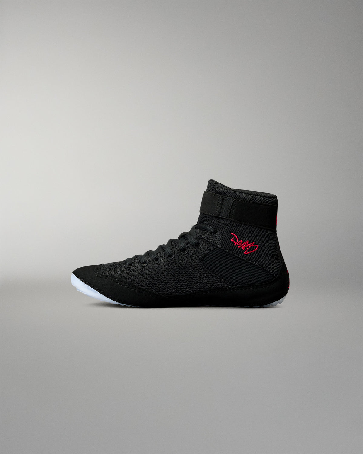 Inner side view of the RUDIS Samurai Speed Youth Wabi-Sabi wrestling shoe, showing black mesh construction, red embroidered signature, ankle strap, and translucent sole.