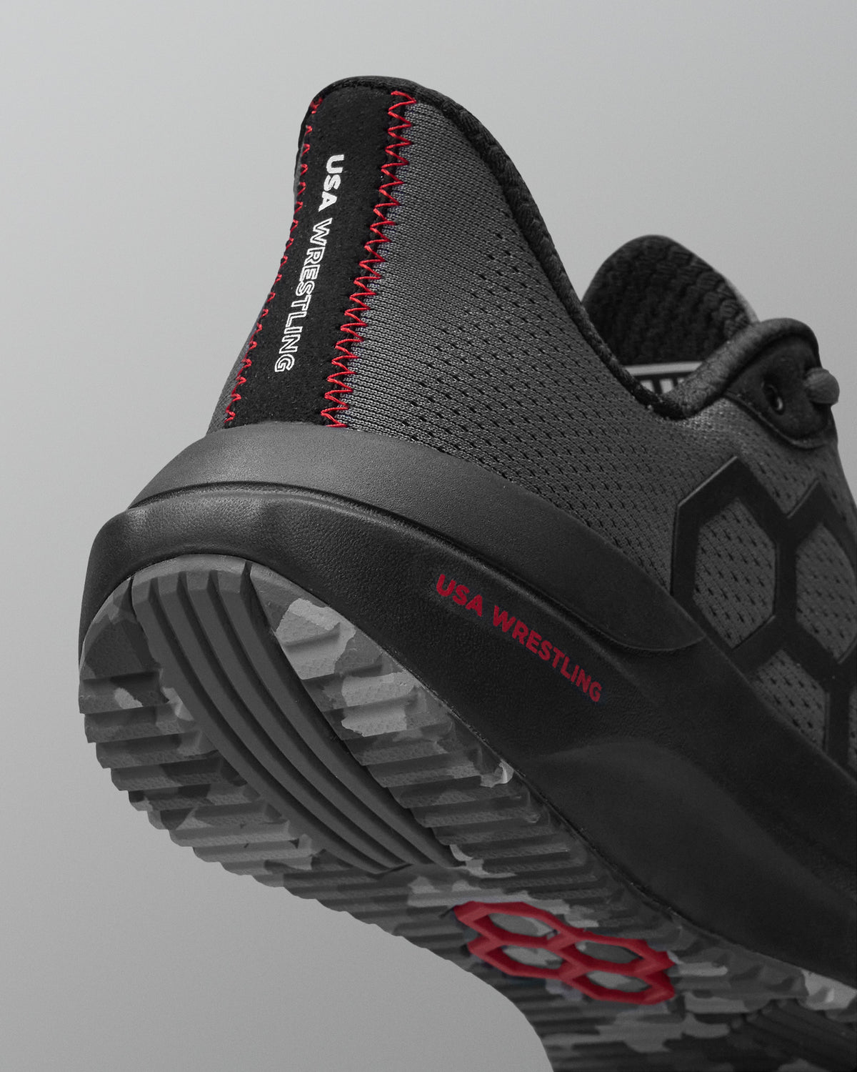 Black and gray wrestling shoe with red accents on a light gray background
