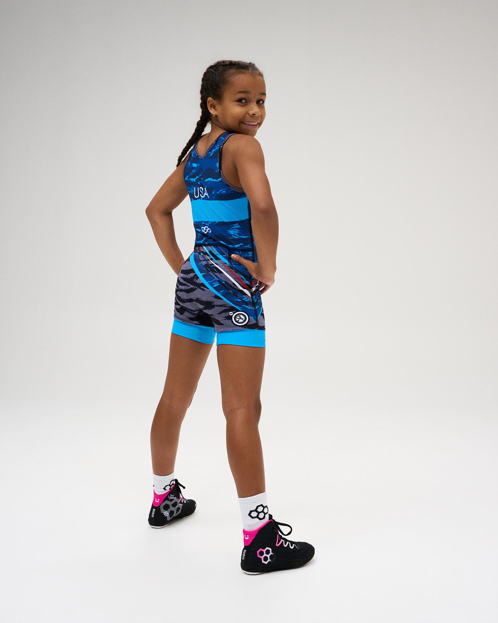 Back view of the USA Wrestling Shooting Star Girls’ Elite 2.0 Singlet in blue, highlighting USA lettering, RUDIS branding, dynamic graphics, and contrasting blue leg bands.